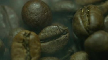 Siyah fonda dönen beyaz dumanlı kavrulmuş kahve çekirdekleri kopyalama alanı