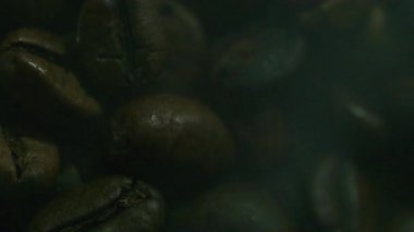 Siyah fonda dönen beyaz dumanlı kavrulmuş kahve çekirdekleri kopyalama alanı