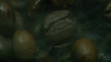 Siyah fonda dönen beyaz dumanlı kavrulmuş kahve çekirdekleri kopyalama alanı