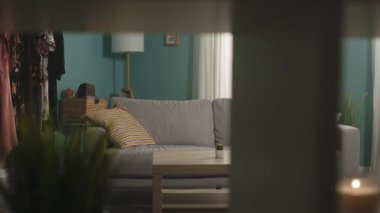 Genç bir kız odaya girer, kanepeye uzanır ve telefonu alır.