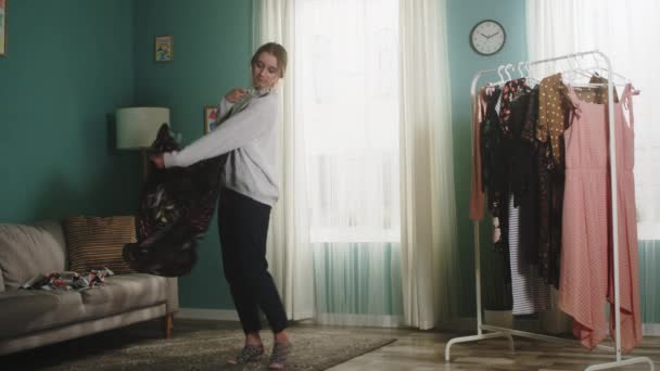 Unga dam väljer en klänning och virvlar med den — Stockvideo