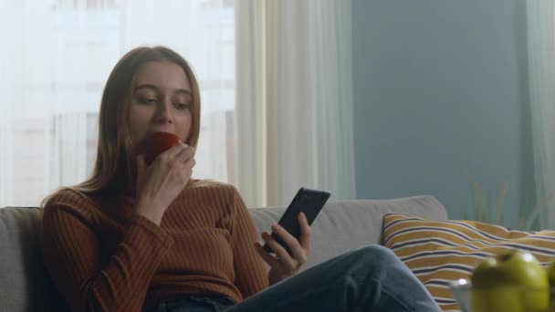 Красивая женщина кусает красное яблоко — стоковое видео