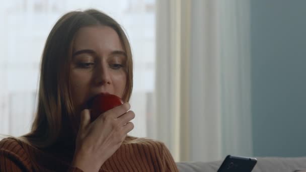 Chica joven muerde manzana roja — Vídeos de Stock