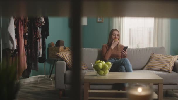 Jong meisje beet een rode appel en stikte — Stockvideo