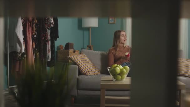 Гарненька леді говорить на відео дзвінок і кусає червоне яблуко — стокове відео