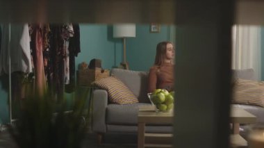 Genç kadın görüntülü konuşuyor ve kırmızı elmayı ısırıyor.