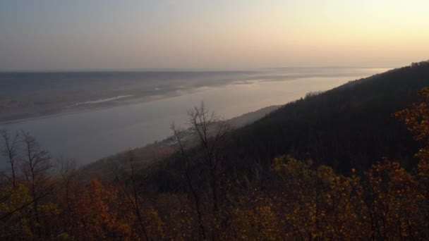 Vista de otoño desde la montaña hasta el gran río, en el bosque con hojas doradas y abetos verdes. Otoño en el bosque. — Vídeo de stock