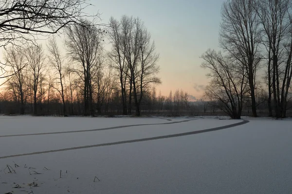 Breath of winter, first ice on the lake, dawn on a frosty morning with frost on the grass, close-up of frost, patterns on the first ice. Winter