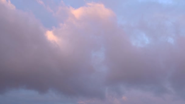 Hermoso cielo azul al atardecer con luz brillante ardiente, nubes iluminadas por rayos de luz solar flotando lentamente a través del cielo. — Vídeo de stock