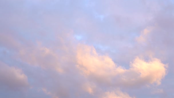 Bela noite céu azul ao pôr-do-sol com luz brilhante ardente, nuvens iluminadas por raios de luz solar flutuando lentamente através do céu. — Vídeo de Stock