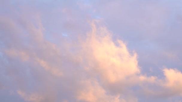 Hermoso cielo azul al atardecer con luz brillante ardiente, nubes iluminadas por rayos de luz solar flotando lentamente a través del cielo. — Vídeos de Stock