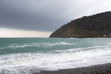 Sakin denizin üzerinde gün doğumu, bulutların arasından bulutların içine, sakin deniz manzarasına, denize doğru, turuncu ışık huzmeleri saçar..