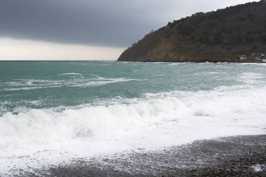 Sakin denizin üzerinde gün doğumu, bulutların arasından bulutların içine, sakin deniz manzarasına, denize doğru, turuncu ışık huzmeleri saçar..