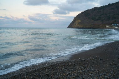 Sakin denizin üzerinde gün doğumu, bulutların arasından bulutların içine, sakin deniz manzarasına, denize doğru, turuncu ışık huzmeleri saçar..