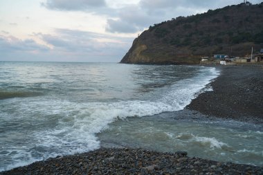 Sakin denizin üzerinde gün doğumu, bulutların arasından bulutların içine, sakin deniz manzarasına, denize doğru, turuncu ışık huzmeleri saçar..