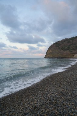 Sakin denizin üzerinde gün doğumu, bulutların arasından bulutların içine, sakin deniz manzarasına, denize doğru, turuncu ışık huzmeleri saçar..