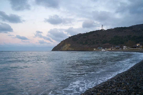 Sakin denizin üzerinde gün doğumu, bulutların arasından bulutların içine, sakin deniz manzarasına, denize doğru, turuncu ışık huzmeleri saçar..
