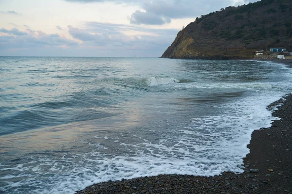 Sakin denizin üzerinde gün doğumu, bulutların arasından bulutların içine, sakin deniz manzarasına, denize doğru, turuncu ışık huzmeleri saçar..