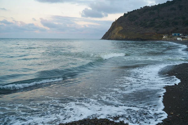 Sakin denizin üzerinde gün doğumu, bulutların arasından bulutların içine, sakin deniz manzarasına, denize doğru, turuncu ışık huzmeleri saçar..