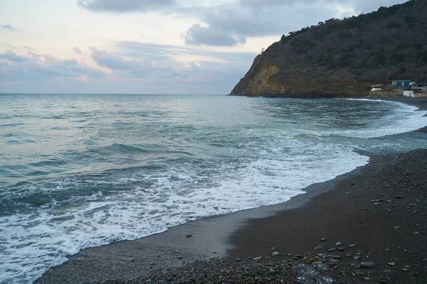 Sakin denizin üzerinde gün doğumu, bulutların arasından bulutların içine, sakin deniz manzarasına, denize doğru, turuncu ışık huzmeleri saçar..
