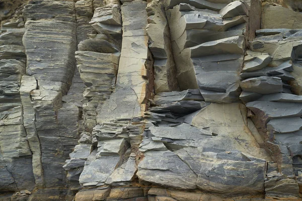 La textura y el fondo de las piedras. Textura de roca en la costa del mar — Foto de Stock