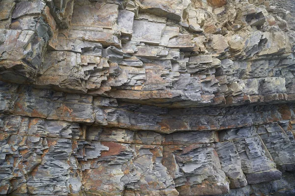 La textura y el fondo de las piedras. Textura de roca en la costa del mar — Foto de Stock