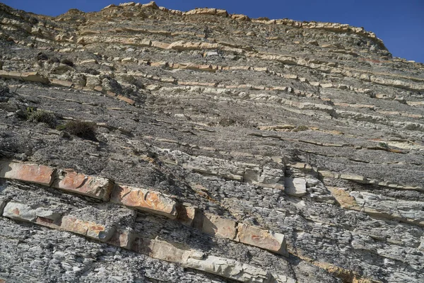 La consistenza e lo sfondo delle pietre. Struttura rocciosa sulla costa del mare — Foto Stock
