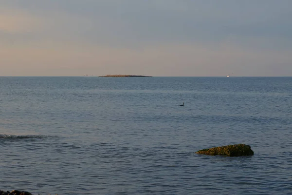 平静的海面上的日出向空中投射出橙色的光芒，夕阳西下的太阳穿过云朵，进入如画的平静的海景- -大海. — 图库照片