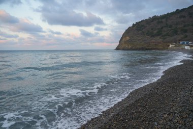 Sakin denizin üzerinde gün doğumu, bulutların arasından bulutların içine, sakin deniz manzarasına, denize doğru, turuncu ışık huzmeleri saçar..