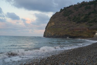 Sakin denizin üzerinde gün doğumu, bulutların arasından bulutların içine, sakin deniz manzarasına, denize doğru, turuncu ışık huzmeleri saçar..