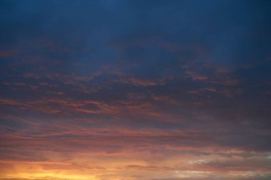 Gün batımında parlayan parlak ışık bulutlarıyla güzel bir akşam masmavi gökyüzü. Gün batımında sıcak bir yaz akşamı. Parlak gün batımı.