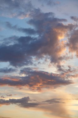 Gün batımında parlayan parlak ışık bulutlarıyla güzel bir akşam masmavi gökyüzü. Gün batımında sıcak bir yaz akşamı. Parlak gün batımı.