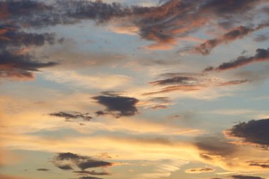 Gün batımında parlayan parlak ışık bulutlarıyla güzel bir akşam masmavi gökyüzü. Gün batımında sıcak bir yaz akşamı. Parlak gün batımı.