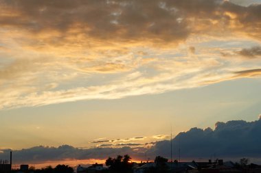 Gün batımında parlayan parlak ışık bulutlarıyla güzel bir akşam masmavi gökyüzü. Gün batımında sıcak bir yaz akşamı. Parlak gün batımı.