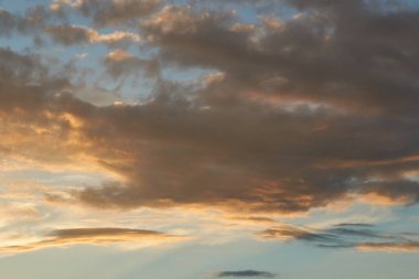 Gün batımında parlayan parlak ışık bulutlarıyla güzel bir akşam masmavi gökyüzü. Gün batımında sıcak bir yaz akşamı. Parlak gün batımı.