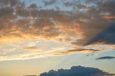 Gün batımında parlayan parlak ışık bulutlarıyla güzel bir akşam masmavi gökyüzü. Gün batımında sıcak bir yaz akşamı. Parlak gün batımı.