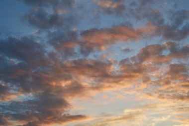 Gün batımında parlayan parlak ışık bulutlarıyla güzel bir akşam masmavi gökyüzü. Gün batımında sıcak bir yaz akşamı. Parlak gün batımı.