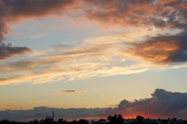 Gün batımında parlayan parlak ışık bulutlarıyla güzel bir akşam masmavi gökyüzü. Gün batımında sıcak bir yaz akşamı. Parlak gün batımı.