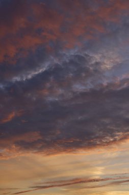 Gün batımında parlayan parlak ışık bulutlarıyla güzel bir akşam masmavi gökyüzü. Gün batımında sıcak bir yaz akşamı. Parlak gün batımı.