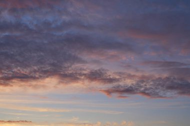 Gün batımında parlayan parlak ışık bulutlarıyla güzel bir akşam masmavi gökyüzü. Gün batımında sıcak bir yaz akşamı. Parlak gün batımı.