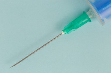 Laboratory, blood sampling and findings, syringe needle painted up close on a blue background