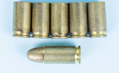 fired bullets, bullet casings photographed up close on a blue background, pistol bullet