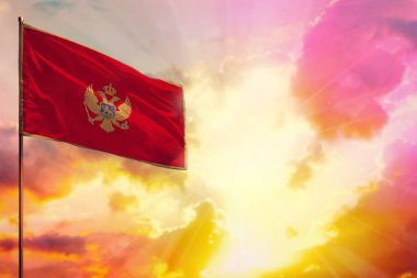 Fluttering Montenegro flag in left top corner mockup with the place for your information on beautiful colorful sunset or sunrise background.