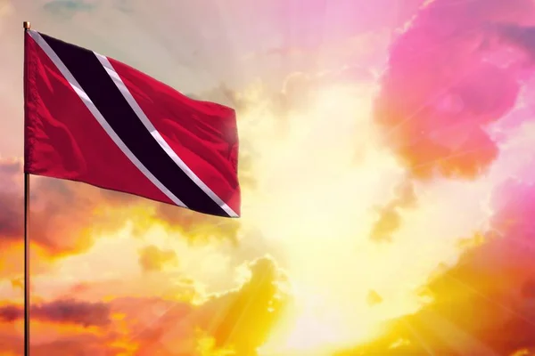 Fluttering Trinidad and Tobago flag in left top corner mockup with the place for your information on beautiful colorful sunset or sunrise background.