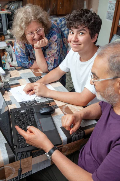 Gelukkig tiener jongen glimlachen terwijl wordt onderwezen door zijn grootouders thuis — Stockfoto