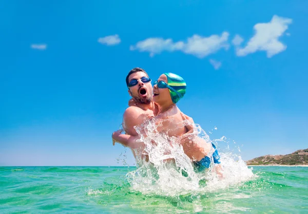 父息子スプラッシュ水海を投げる — ストック写真