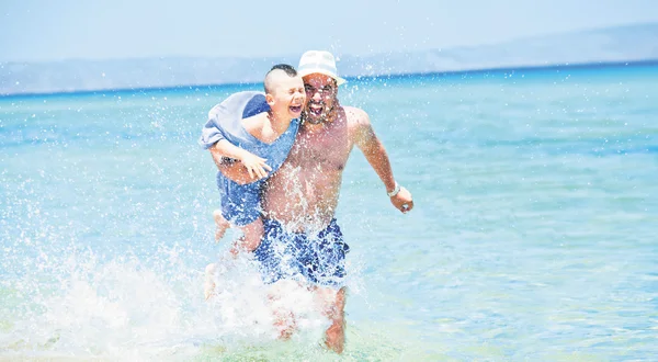 海を実行する父息子水しぶき — ストック写真