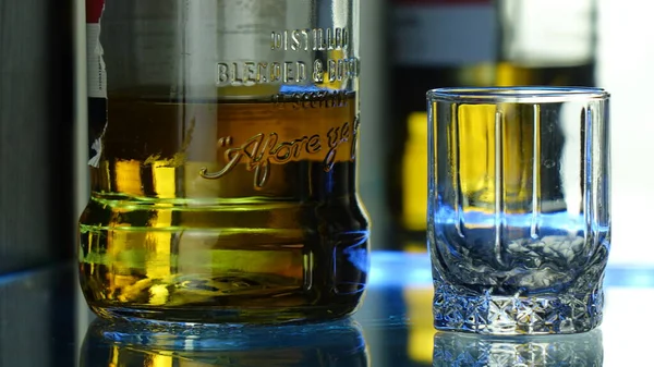 Cam yüzeyde bir bardak ve bir şişe viski..