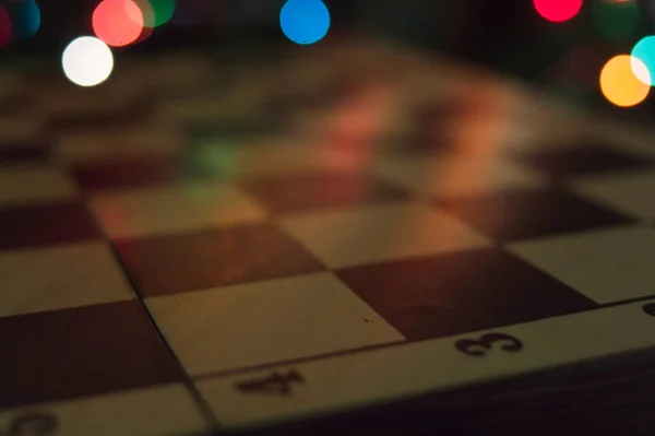 Renk ışıkları arka planında ahşap satranç tahtası