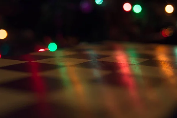 Renk ışıkları arka planında ahşap satranç tahtası